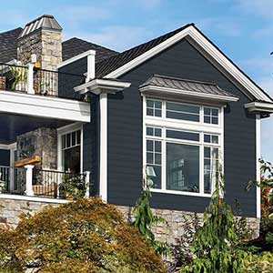 Front view of a high-end two-story home with dark blue, almost black Alside siding